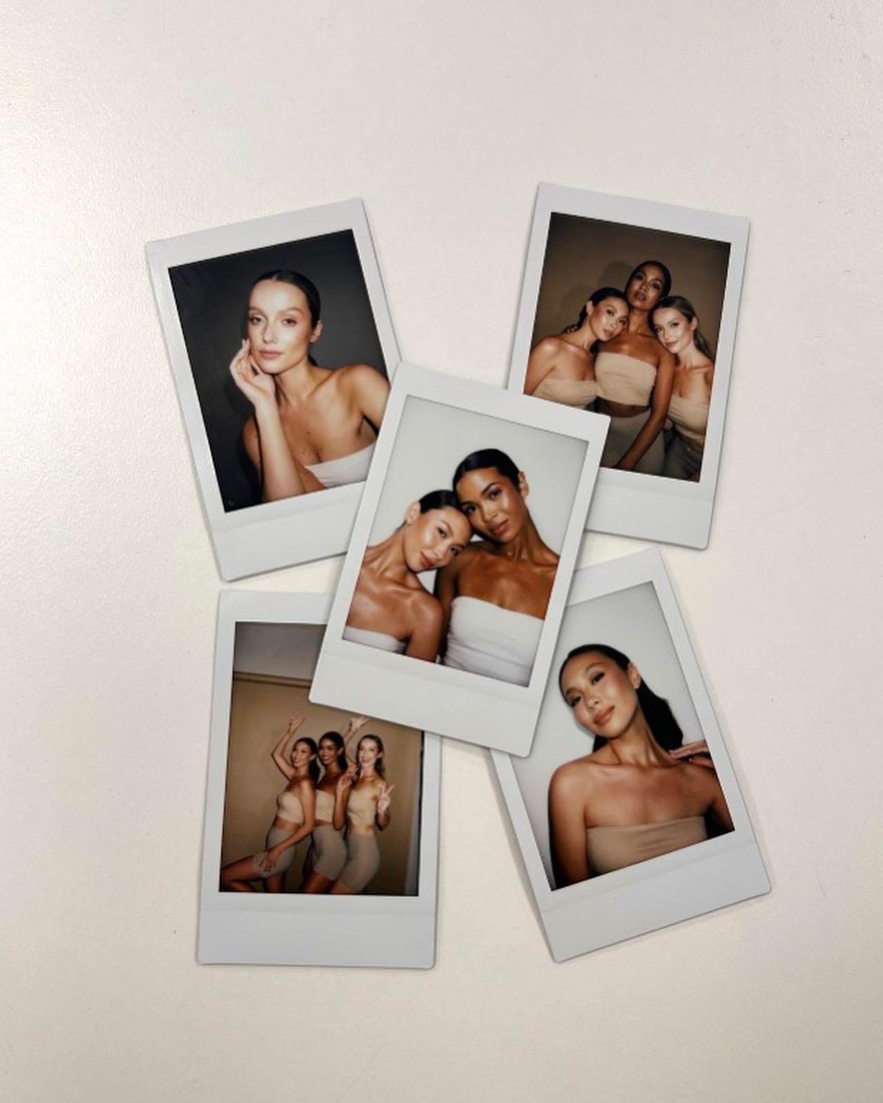 Five Polaroid-style instant photos arranged on a white surface. Each photo features young women posing in neutral-toned outfits, mostly beige or tan tube tops and skirts or shorts. The images capture different groupings and solo shots, with the women smiling, making peace signs, or posing thoughtfully against plain backdrops.